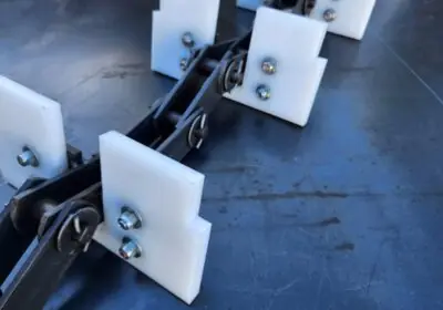 Accesorios fabricados en UHMW por Cadenas Metalplas para transportadores industriales con mecanizado CNC de alta precision.